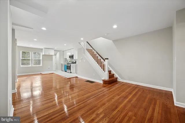 a view of empty room with wooden floor and stairs