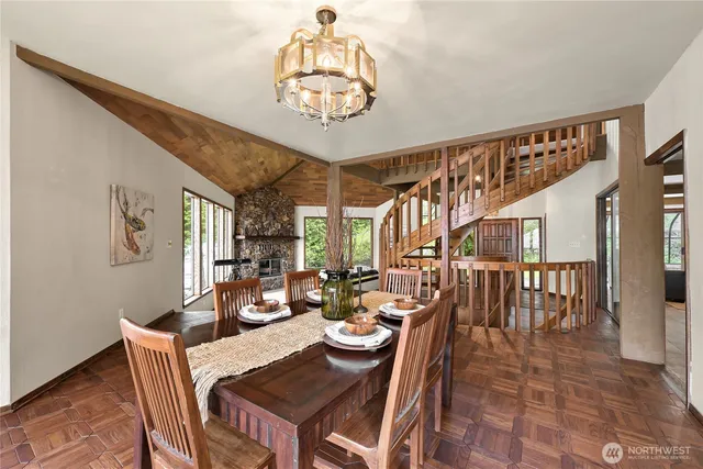 a view of a dining room with furniture a chandelier and wooden floor