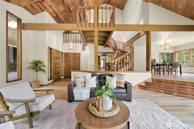 a living room with furniture kitchen view and a chandelier