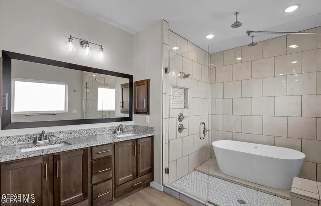 a bathroom with a granite countertop sink a toilet a mirror and bathtub
