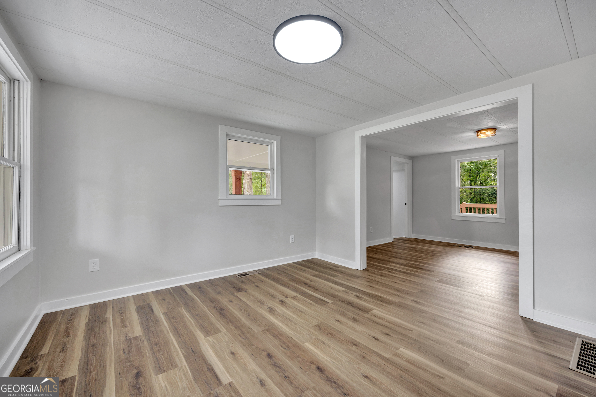 455 Cindy Street Jackson, GA 30233 - Photo 4 of 25 an empty room with wooden floor and windows