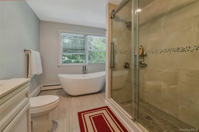 a bathroom with a white toilet a bath tub and shower