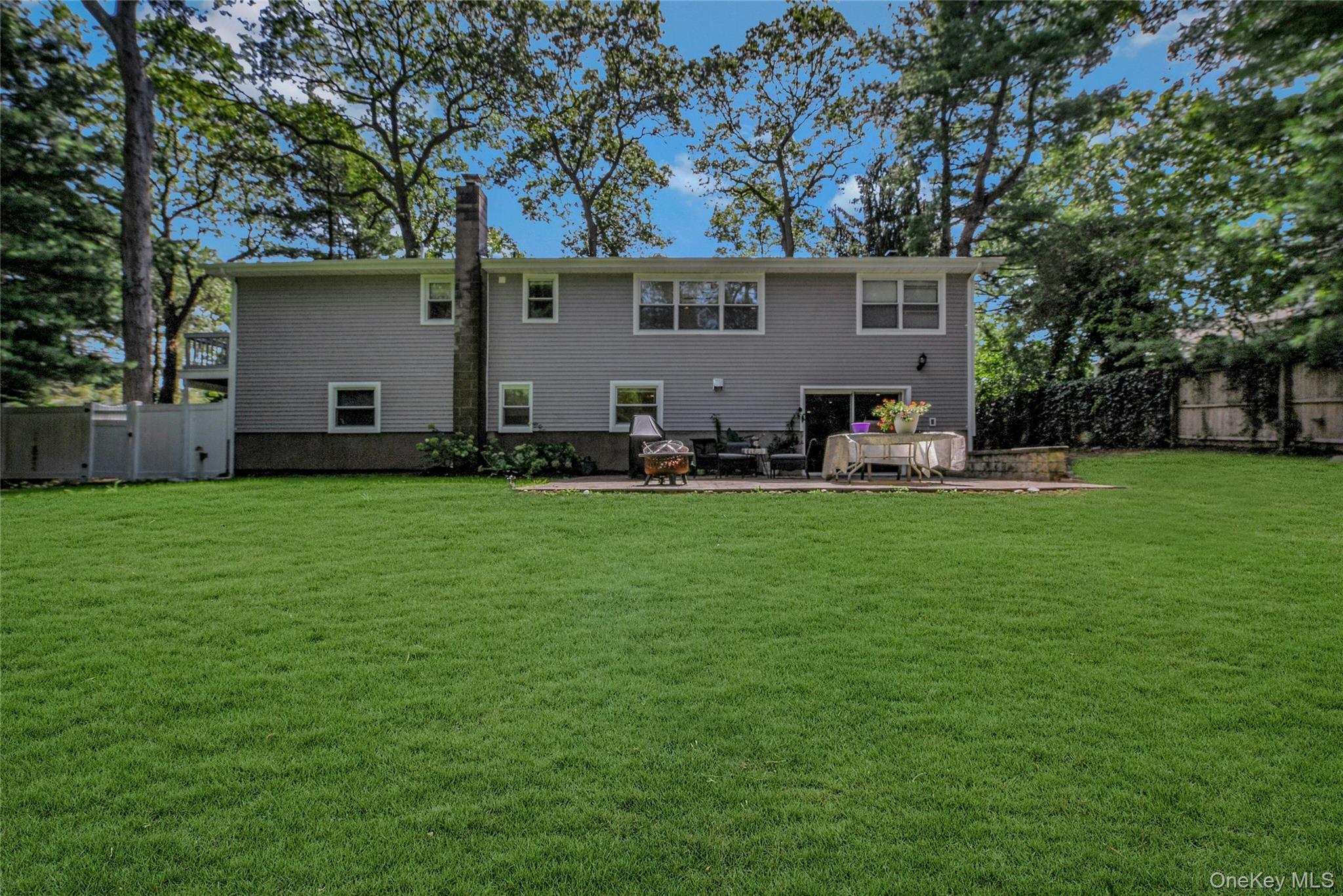 27 Upper Sheep Pasture Road East Setauket, NY 11733 - Photo 23 of 25 a front view of house with yard and seating area