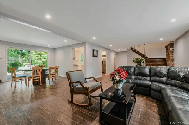 a living room with furniture and a dining table with wooden floor