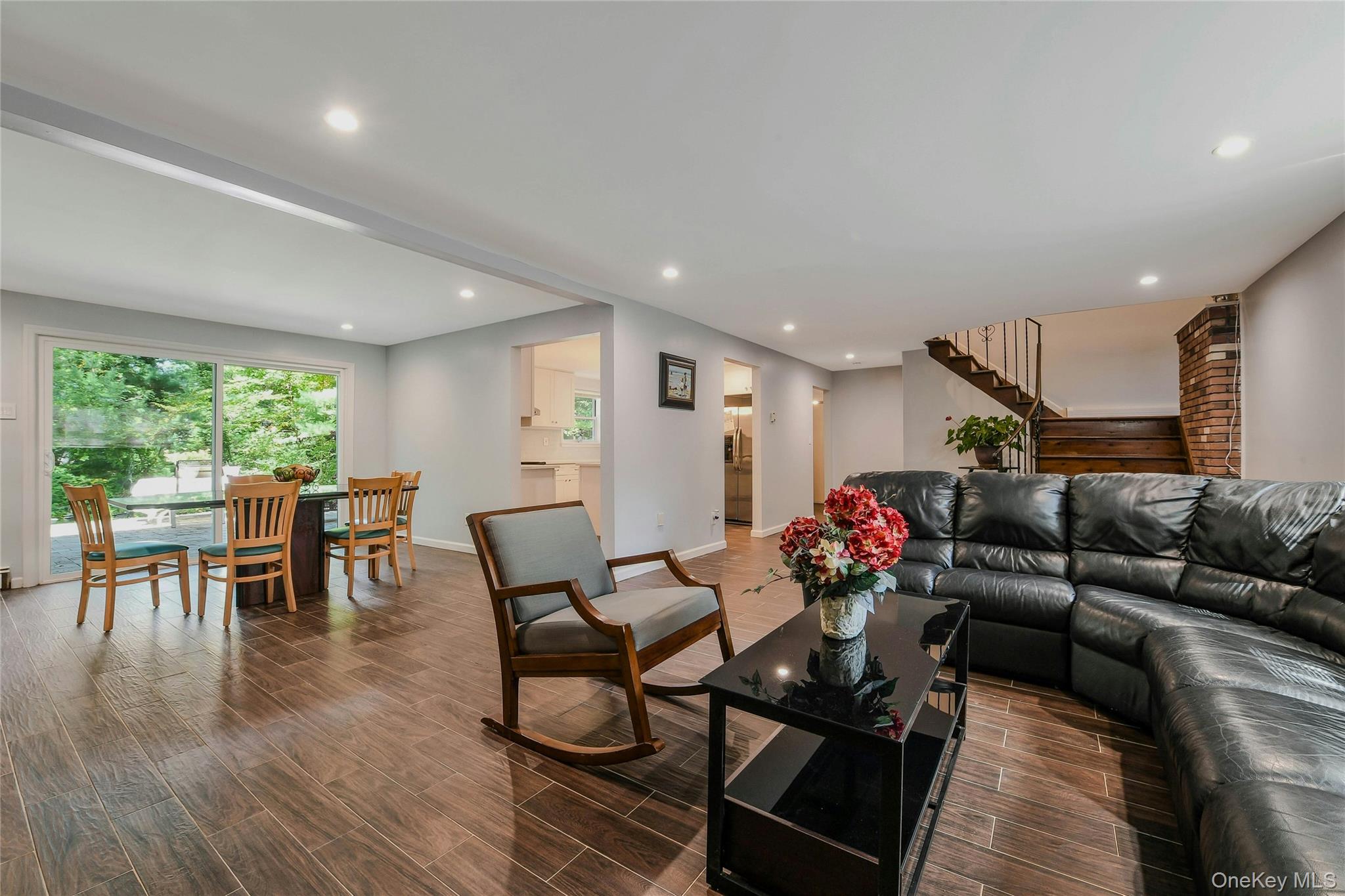 27 Upper Sheep Pasture Road East Setauket, NY 11733 - Photo 5 of 25 a living room with furniture and a dining table with wooden floor