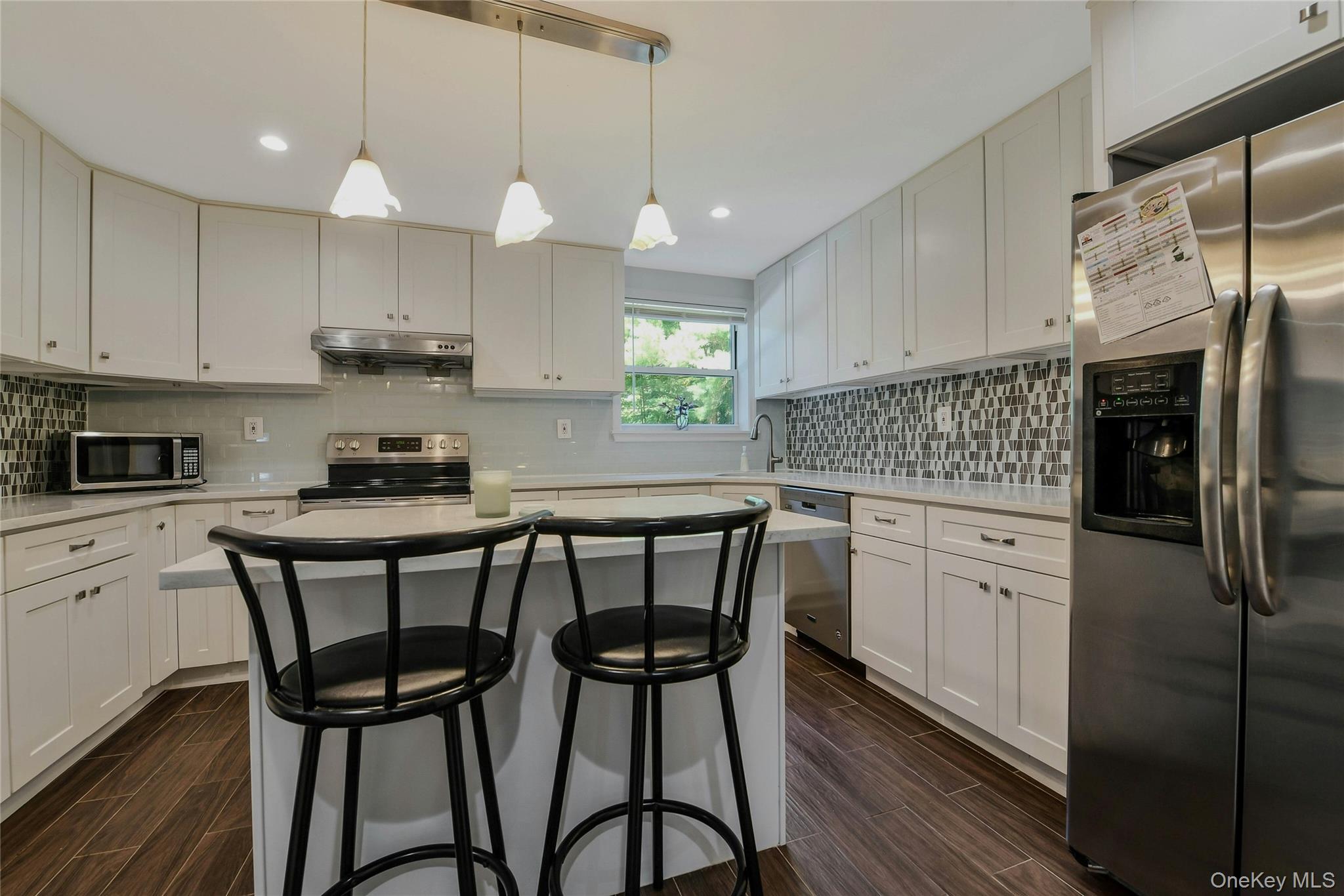 27 Upper Sheep Pasture Road East Setauket, NY 11733 - Photo 7 of 25 a kitchen with stainless steel appliances granite countertop a white table chairs refrigerator and sink
