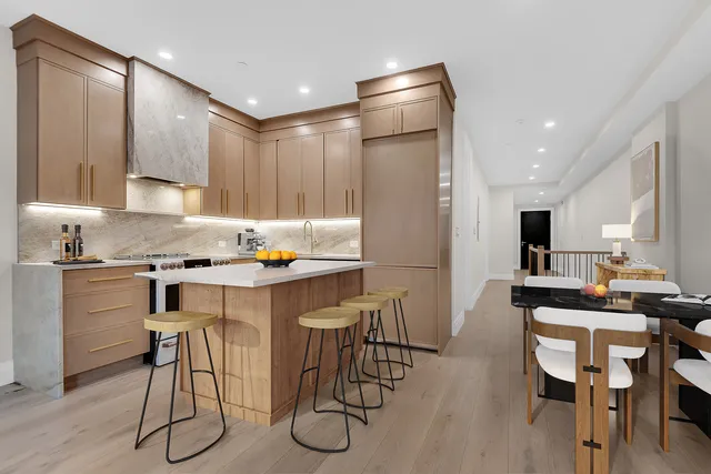 a kitchen with stainless steel appliances granite countertop a sink a stove and a refrigerator with wooden floor