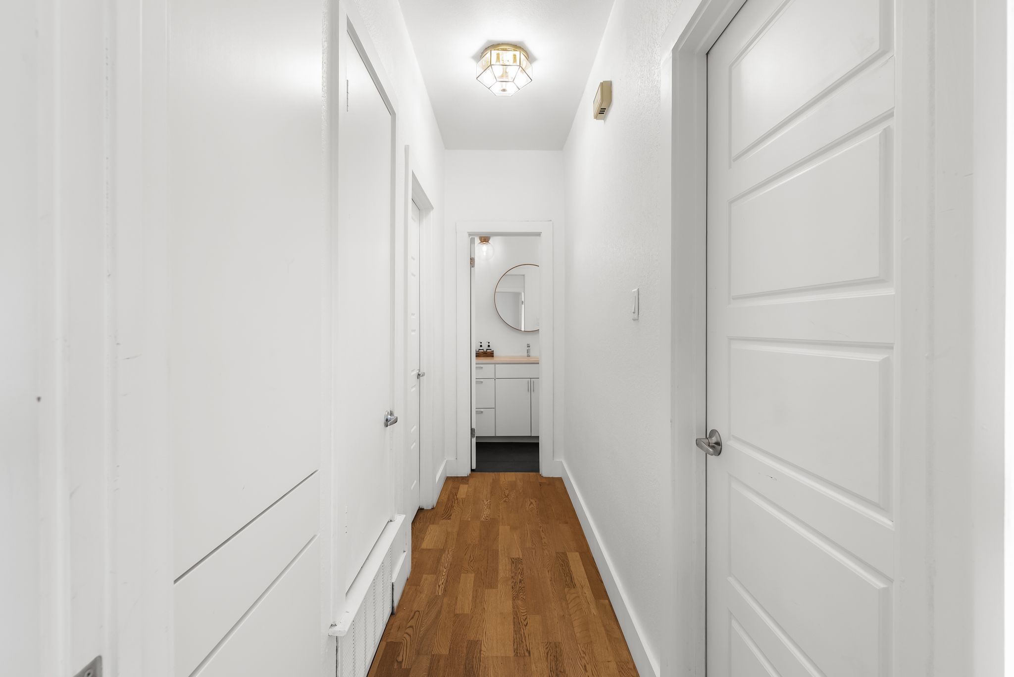 1714 Prairie Hen Cove Austin, TX 78758 - Photo 22 of 35 a view of a hallway with wooden floor and a bathroom