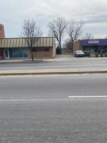 a view of a house with a large space and a car parked on road