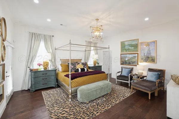 a living room with furniture a flat screen tv and a chandelier