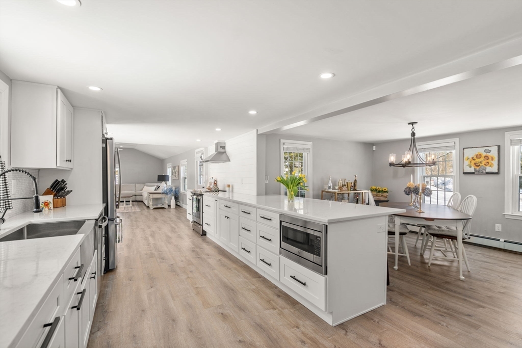 738 Whiting Street Hanover, MA 02339 - Photo 17 of 32 a kitchen with white cabinets and wooden floors