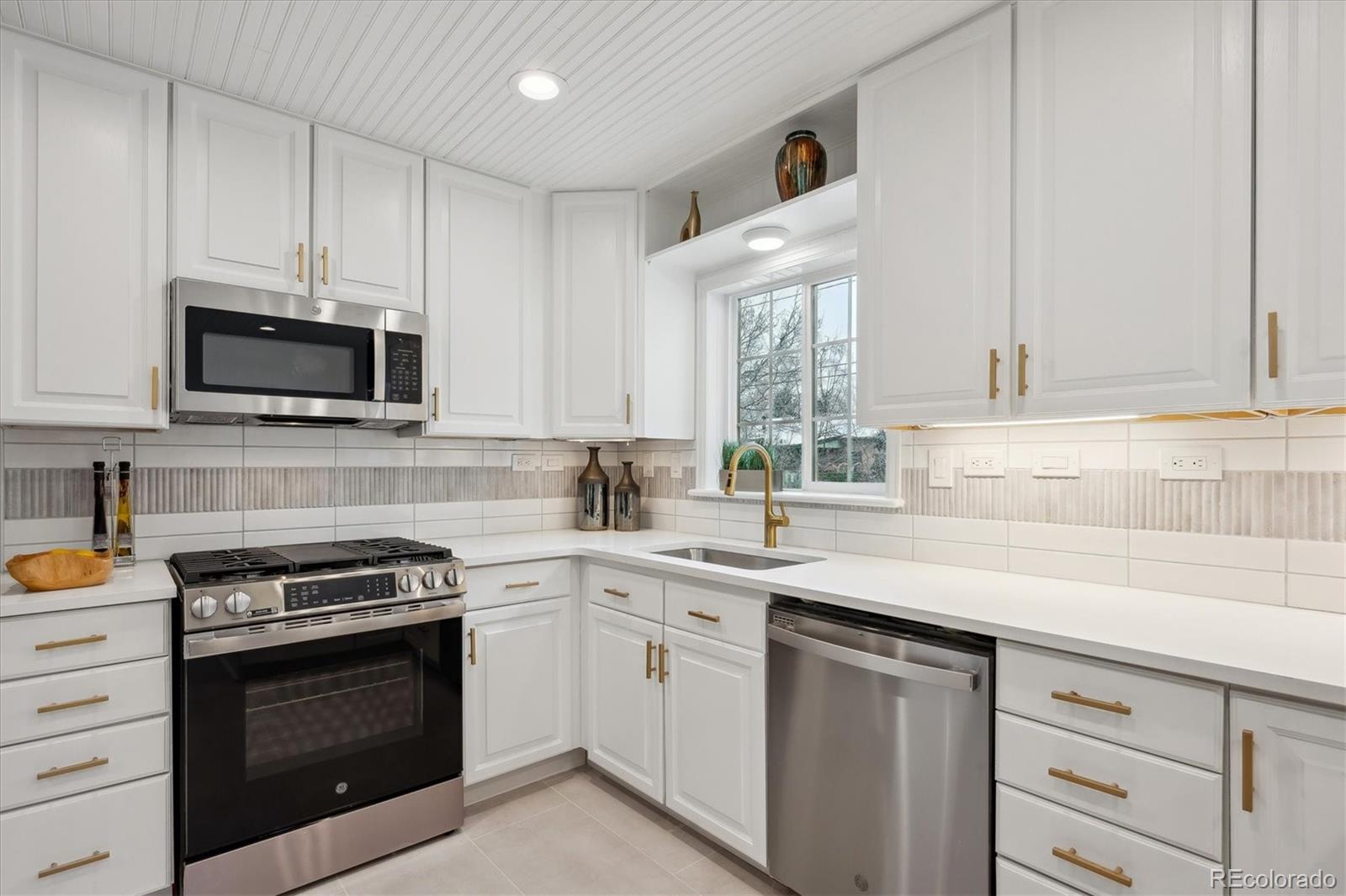 6300 Janice Way Arvada, CO 80004 - Photo 11 of 33 a kitchen with white cabinets and appliances