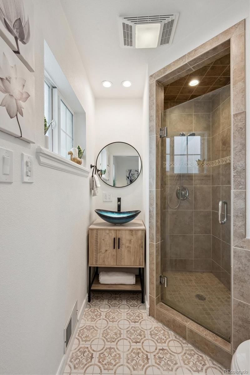 6300 Janice Way Arvada, CO 80004 - Photo 17 of 33 a bathroom with a mirror and a shower