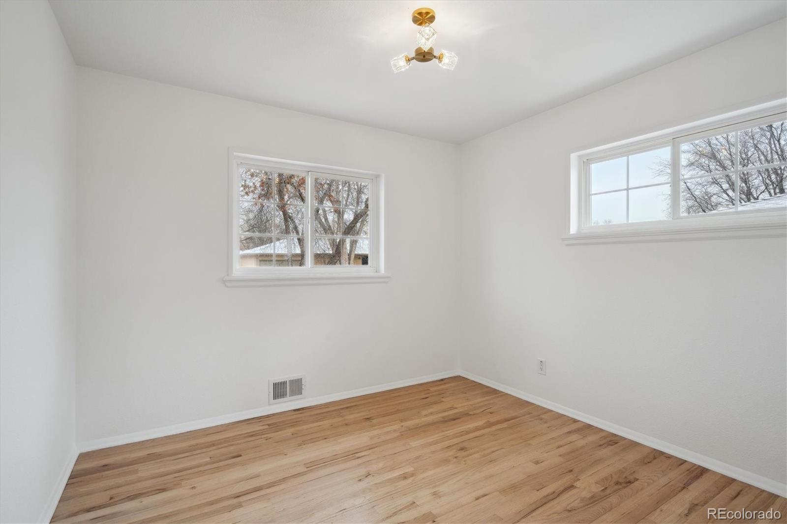 6300 Janice Way Arvada, CO 80004 - Photo 18 of 33 a view of empty room with wooden floor and fan