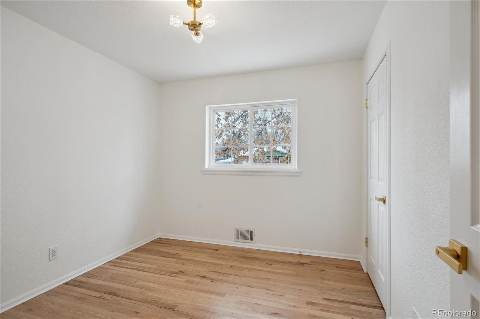 6300 Janice Way Arvada, CO 80004 - Photo 21 of 33 a view of an empty room with wooden floor
