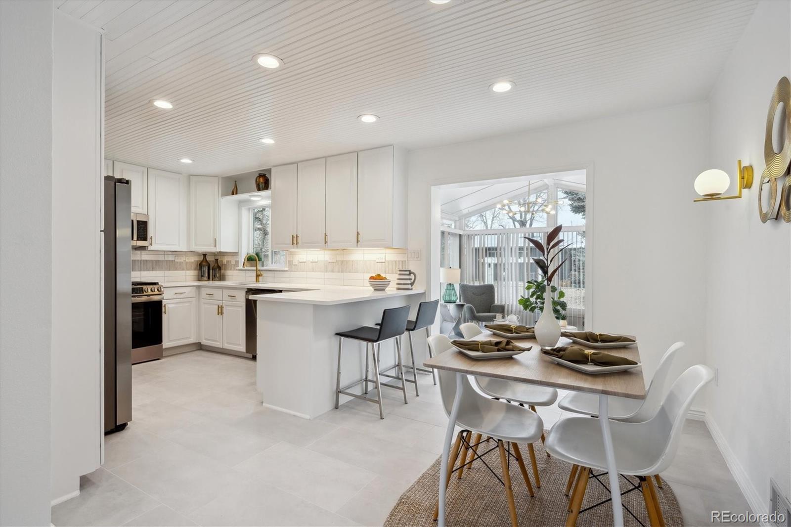 6300 Janice Way Arvada, CO 80004 - Photo 7 of 33 a kitchen with a table chairs stove and cabinets