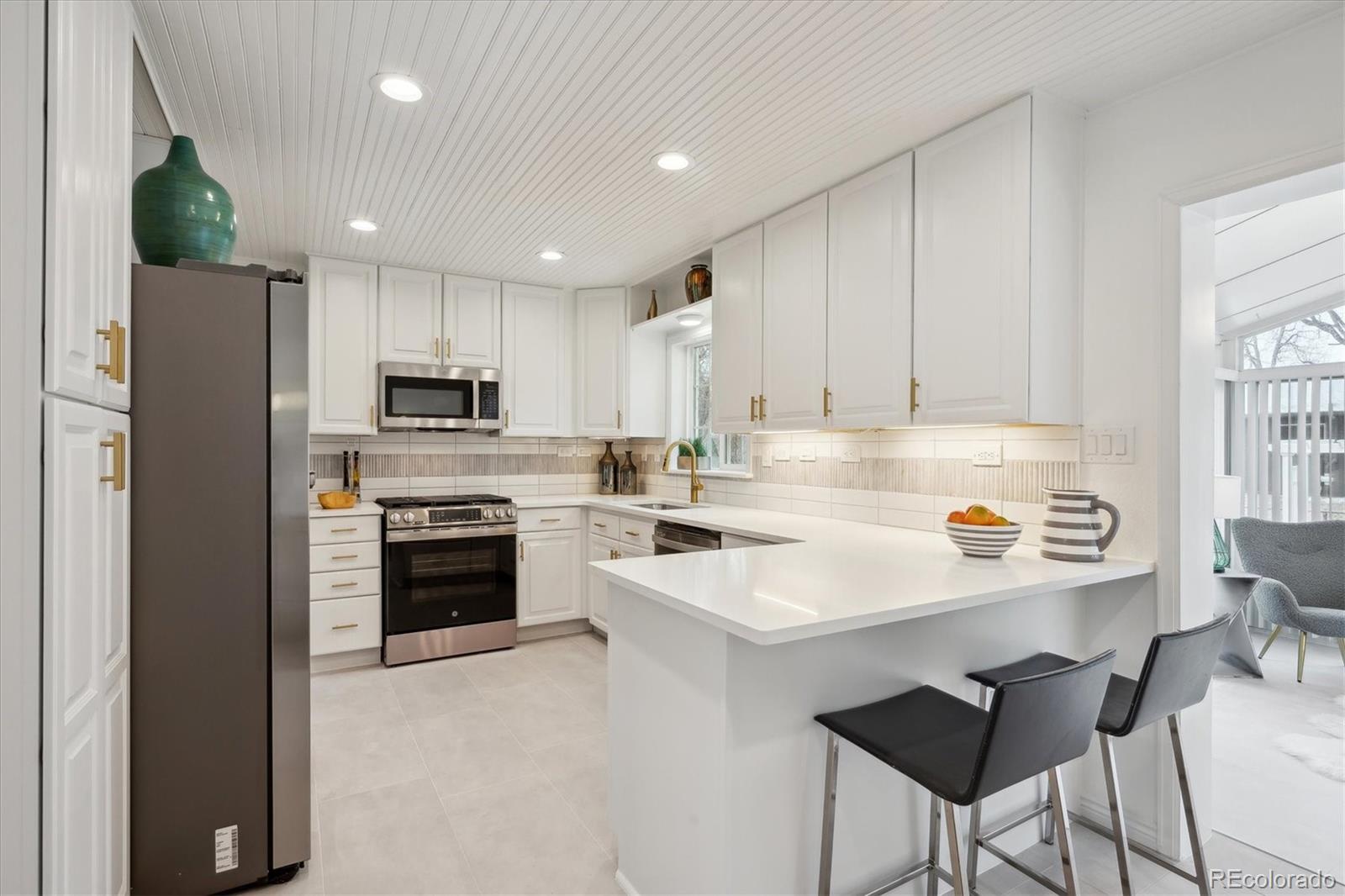 6300 Janice Way Arvada, CO 80004 - Photo 8 of 33 a kitchen with kitchen island granite countertop white cabinets and stainless steel appliances