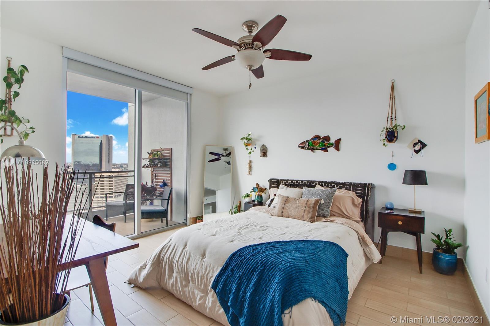 90 Southwest 3rd Street, Unit 2406 Miami, FL 33130 - Photo 3 of 12 a bed sitting in a bedroom next to a larger window with wooden floor