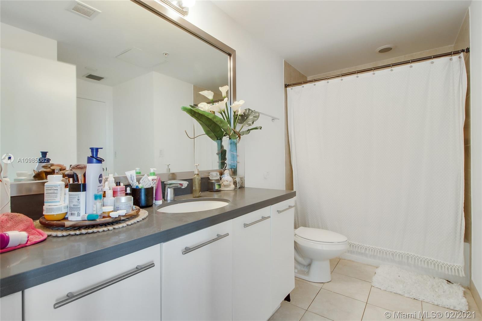 90 Southwest 3rd Street, Unit 2406 Miami, FL 33130 - Photo 7 of 12 a bathroom with a toilet sink and mirror