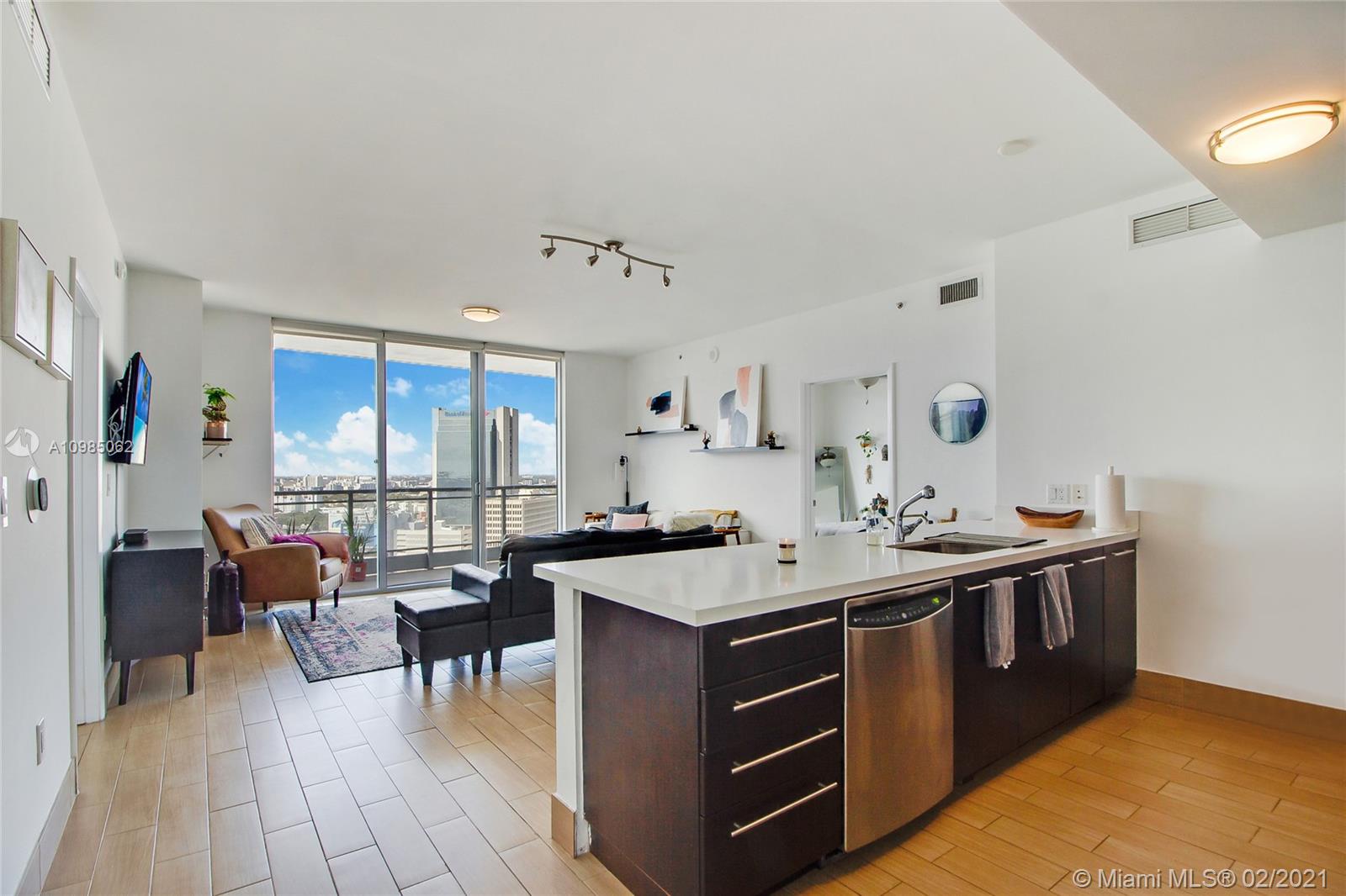 90 Southwest 3rd Street, Unit 2406 Miami, FL 33130 - Photo 9 of 12 a room with stainless steel appliances kitchen island granite countertop a sink and a refrigerator
