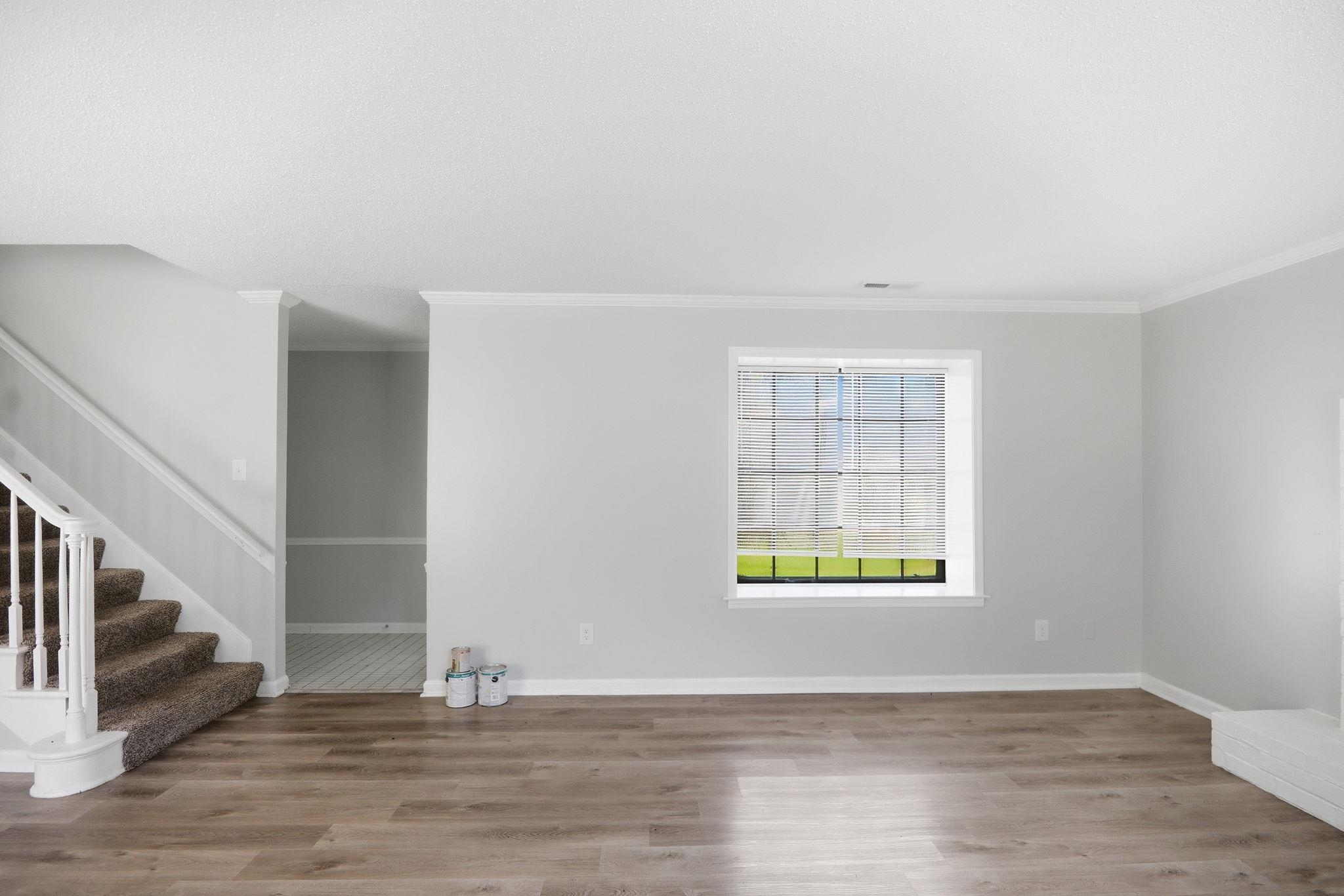 3113 Raleigh Ridge Cove Memphis, TN 38128 - Photo 7 of 38 Spacious room featuring wood-finish flooring, a window with horizontal blinds, light gray walls, white baseboards, and crown molding