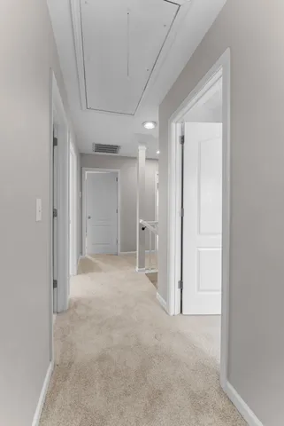 an empty room with chandelier fan and windows