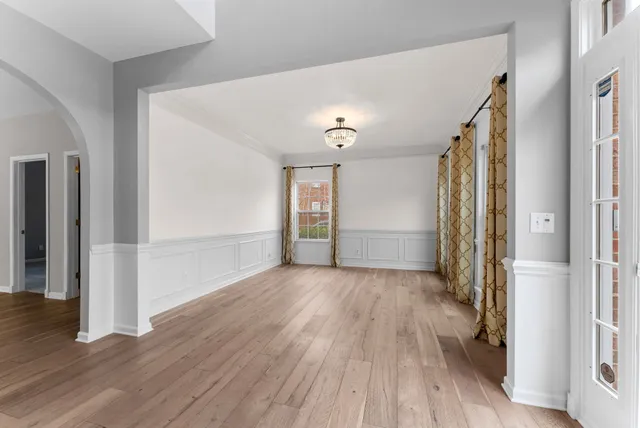 a view of a livingroom with wooden floor and a ceiling fan