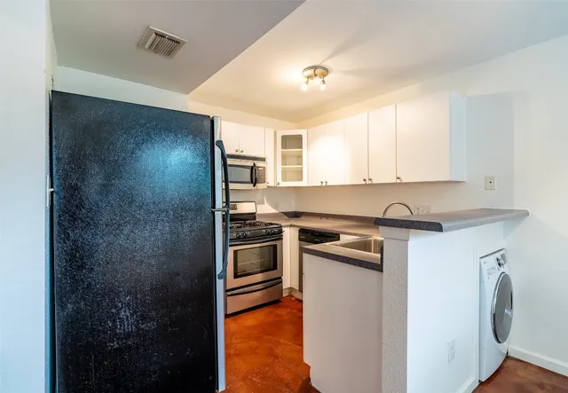 a kitchen with a refrigerator sink and stove top oven