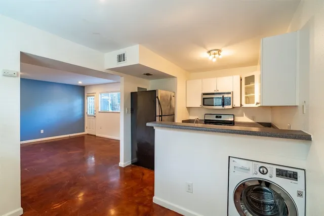 a view of a kitchen with stainless steel appliances a refrigerator and a sink