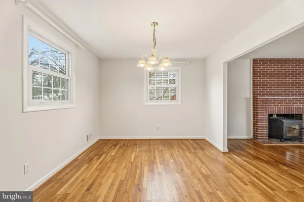 a view of empty room with wooden floor and fireplace