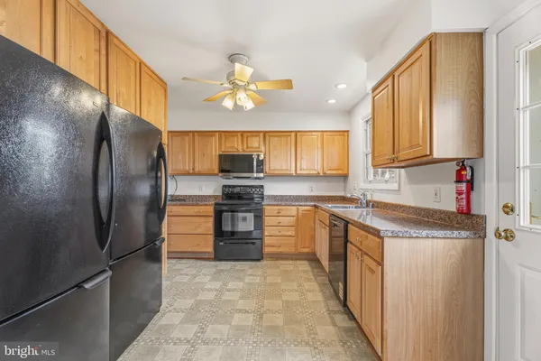 a kitchen with stainless steel appliances granite countertop a refrigerator a stove and a sink with granite countertops