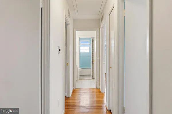 a view of a hallway with wooden floor
