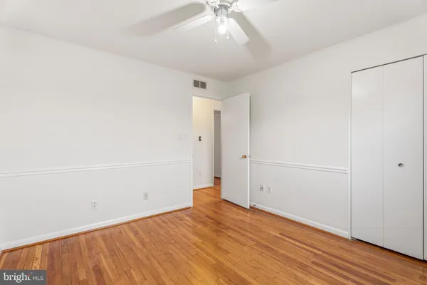 a bedroom with a large bed a potted plant and a window
