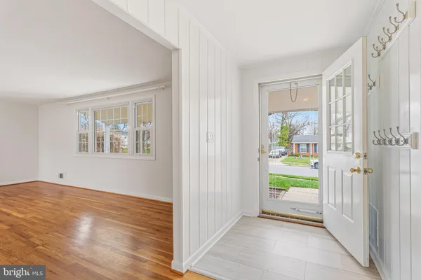 a view of an entryway with wooden floor and a living room