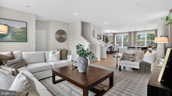 a living room with furniture kitchen view and a large window