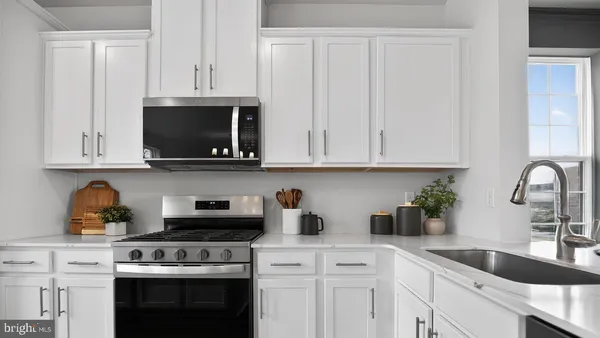 a kitchen with stainless steel appliances granite countertop white cabinets a sink and dishwasher