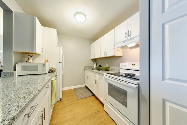 a kitchen with granite countertop cabinets stainless steel appliances and a counter space