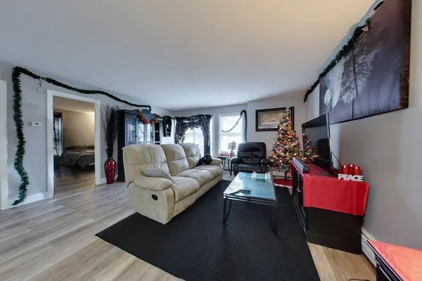 a living room with furniture and a wooden floor