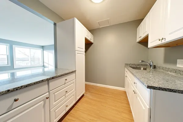 a bathroom with a granite countertop double vanity sink and mirror