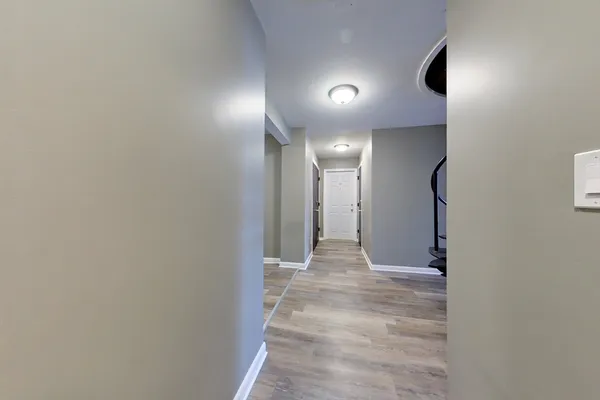 a view of hallway with a large window and a glass door