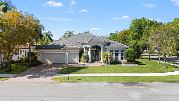a front view of a house with a yard and potted plants