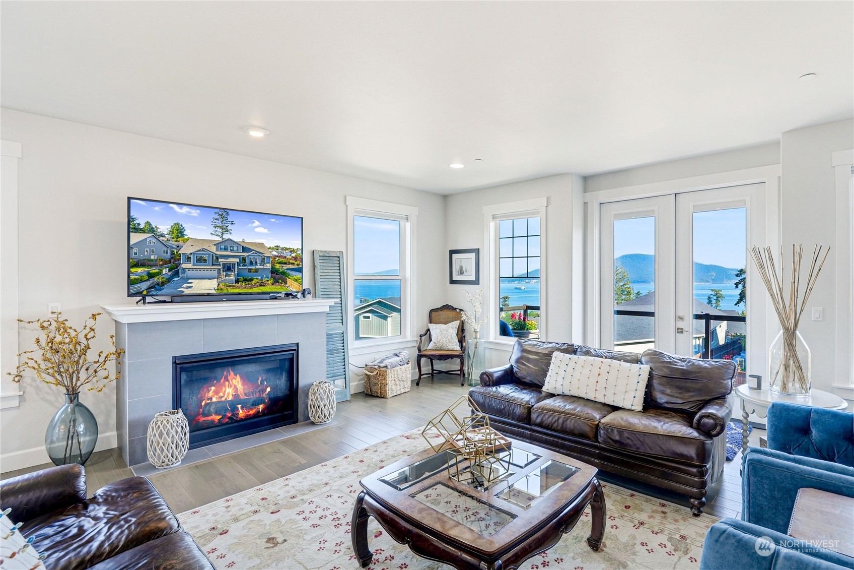 1520 Latitude Circle Anacortes, WA 98221 - Photo 7 of 35 a living room with furniture a fireplace a flat screen tv and a large window
