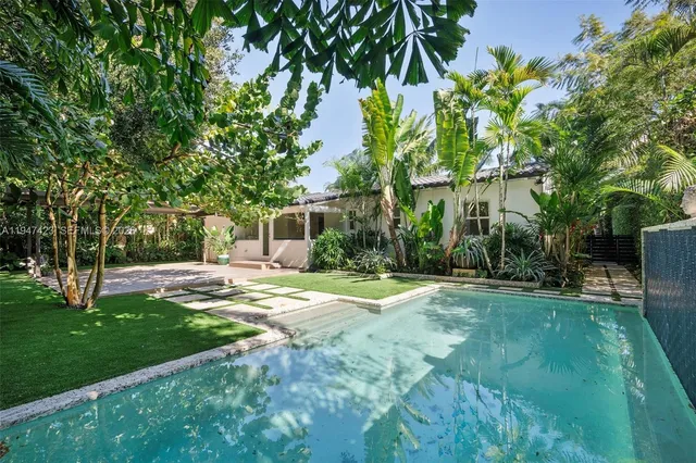 a view of a house with backyard and sitting area