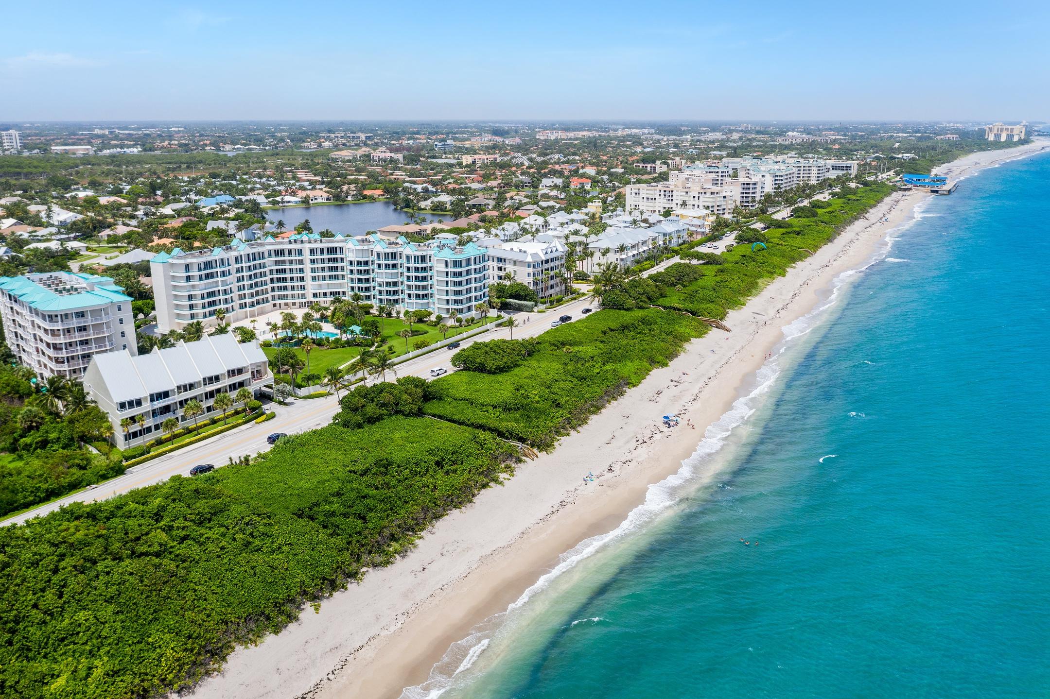 2050 Florida A1A, Unit 3 Jupiter, FL 33477 - Photo 2 of 36 an aerial view of a city with lots of residential buildings ocean and mountain view in back