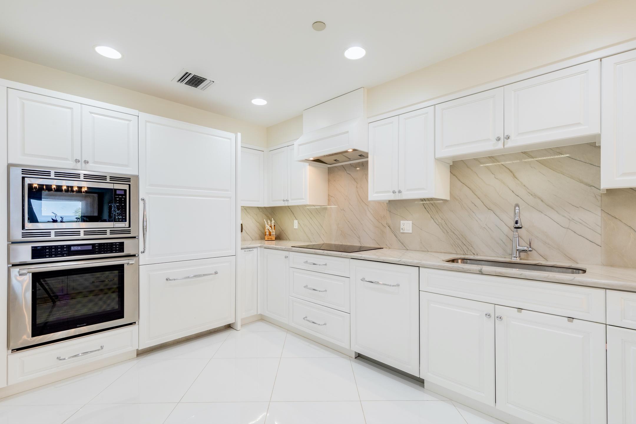 2050 Florida A1A, Unit 3 Jupiter, FL 33477 - Photo 20 of 36 a kitchen with granite countertop white cabinets and stainless steel appliances