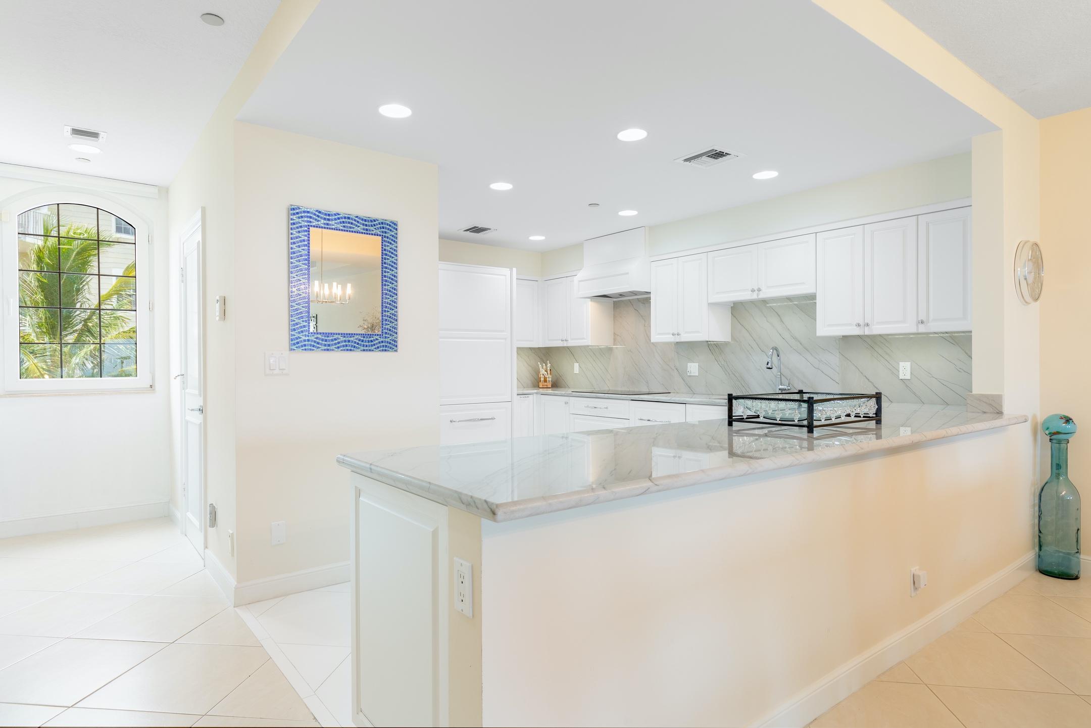 2050 Florida A1A, Unit 3 Jupiter, FL 33477 - Photo 21 of 36 a kitchen with stainless steel appliances granite countertop a sink refrigerator and cabinets