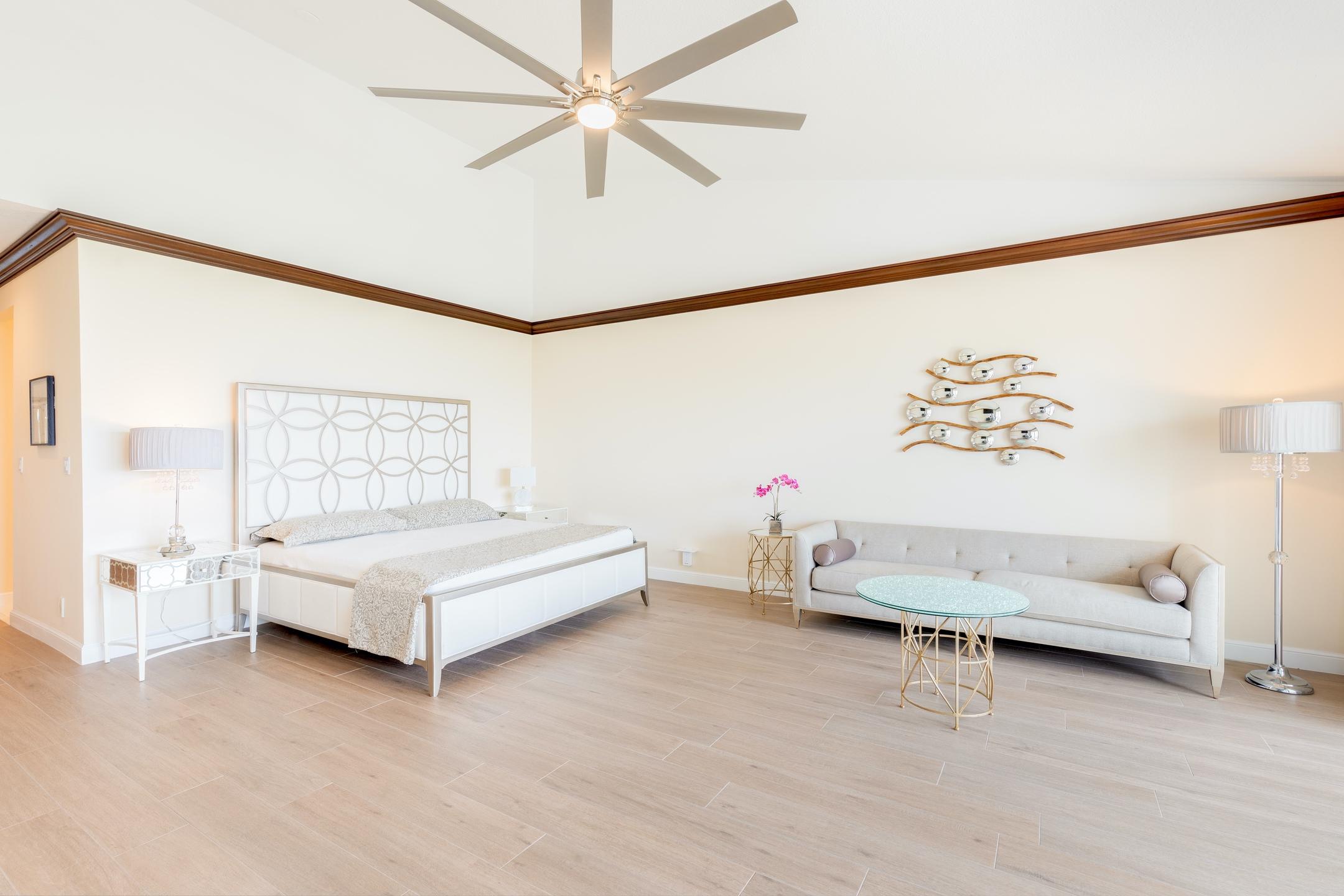 2050 Florida A1A, Unit 3 Jupiter, FL 33477 - Photo 28 of 36 a spacious bedroom with a bed and a chandelier