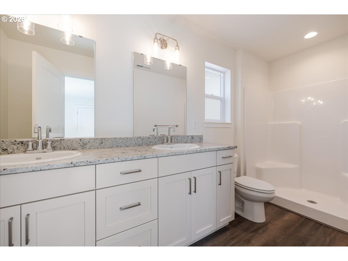 1449 Southeast Hankel Street Dallas, OR 97338 - Photo 13 of 19 a bathroom with a granite countertop sink a toilet and a mirror