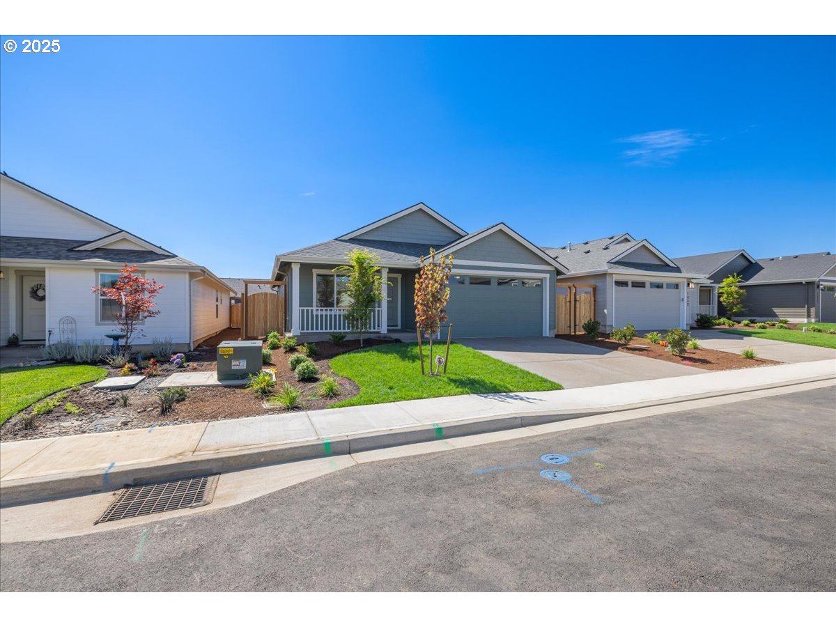 1449 Southeast Hankel Street Dallas, OR 97338 - Photo 19 of 19 a view of a house with a yard and table and chairs under an umbrella