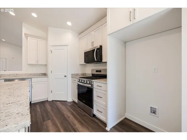 a kitchen with a refrigerator stove and white cabinets